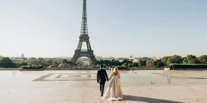 woman and man walking in park in front of eiffel tower