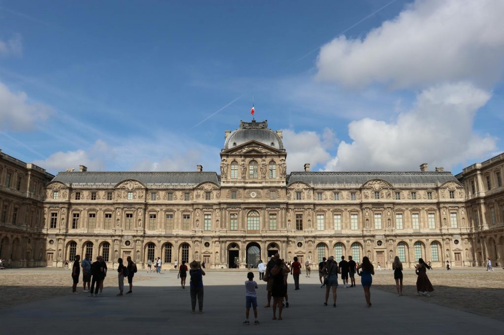 louvre museum paris facade with visitors