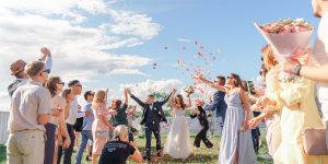 newlyweds and people under confetti