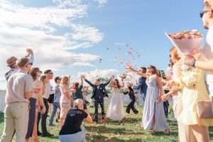 newlyweds and people under confetti